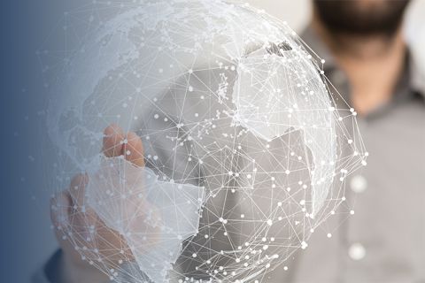 A man stretches out his arm and points with his index finger to a networked globe graphic in the foreground. 